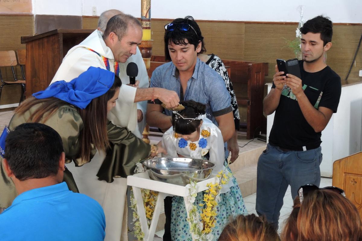 A young girl is baptized at La Tirana. Many families defer sacraments so that these can be celebrated during the feast.