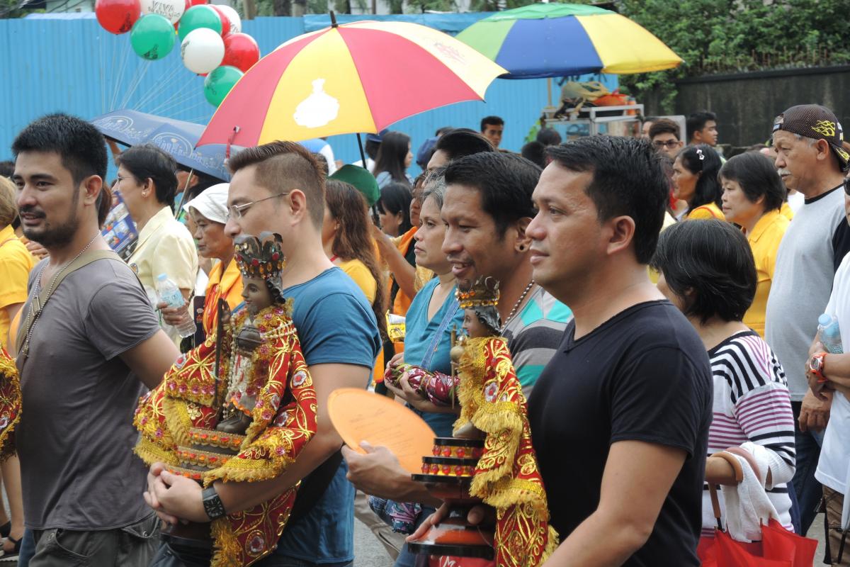 Filipino men carry images of Santo Niño in a procession during the feast in Cebu.