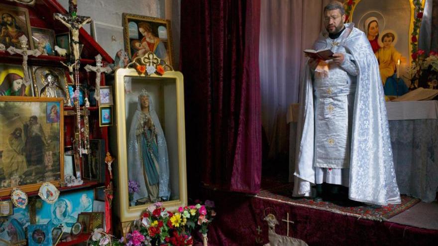 Armenian Catholic liturgy in the Surb Hovhannes (St. John the Baptist) chapel in Metsavan, Armenia. The interior of the temple is filled with votive offerings presented by the faithful. Photograph by Konrad Siekierski.