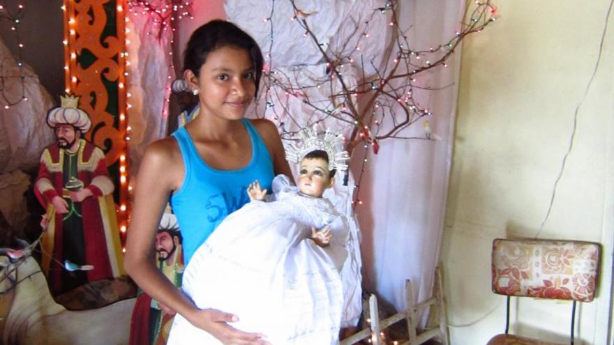 The Niño Dios de María, held by the daughter of the majordomo, in Izalco, El Salvador.