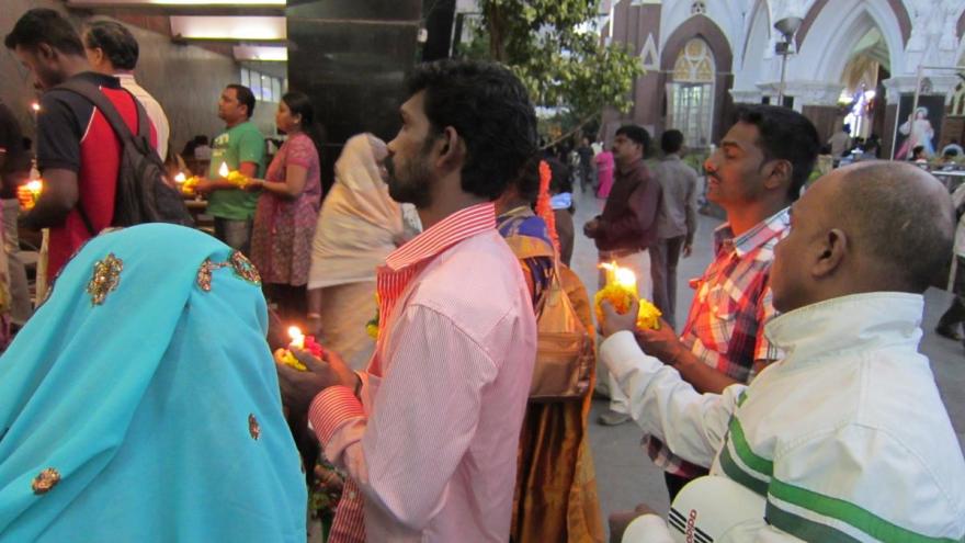 Worshipers before a statue of the Virgin at Saint Mary's Basilica, Bangalore, India.