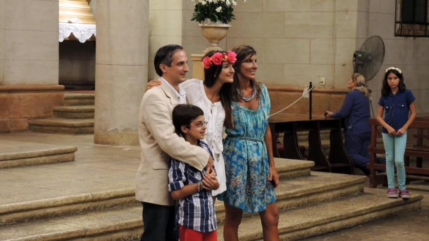A young woman poses with her family after her quinceañera Mass.