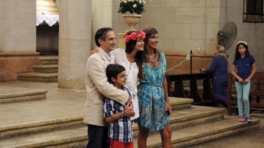 A young woman poses with her family after her quinceañera Mass. Our Lady of the Valley Church, Yerba Buena, Argentina. A young woman poses with her family after her quinceañera Mass.