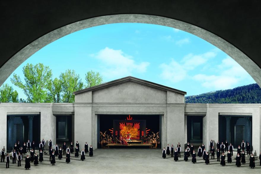 A wide view of the stage framed by the arched roof over the auditorium shows the open air temple with actors in plague era costumes flanking a colorful tableau vivant of Adam and Eve and the tree of life at the loss of paradise center stage.