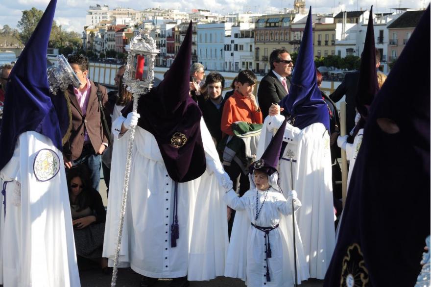 La Estrella (the Star) confraternity begins its procession across the bridge to the center city of Seville.