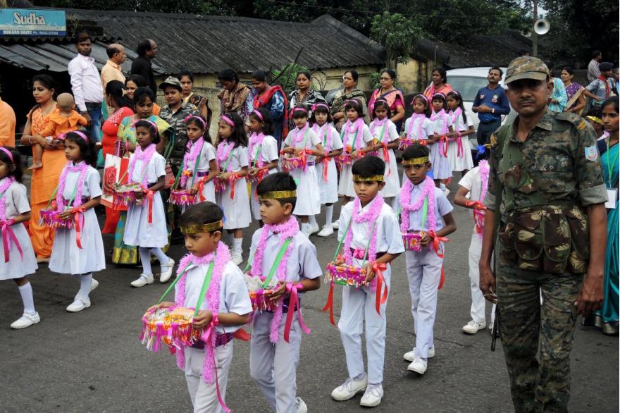 Children carry offerings to Dhori Mata in procession.