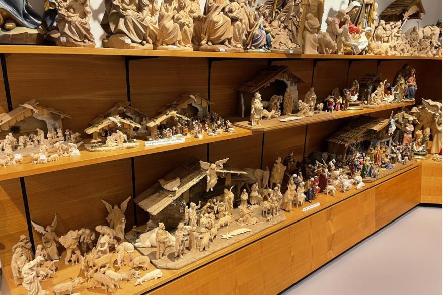 Wood carved nativity sets line display shelves inside a shop in Oberammergau.
