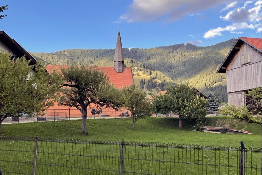 Landscape view of the Protestant Church with a red pitched roof and steeple.
