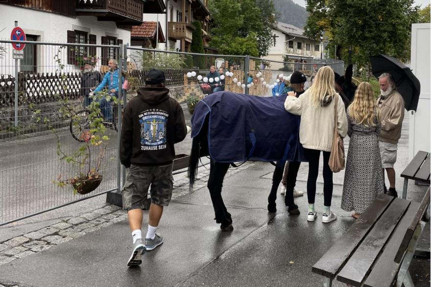 In a lot behind the theater, stagehands chat and laugh and pet a horse used in the play.