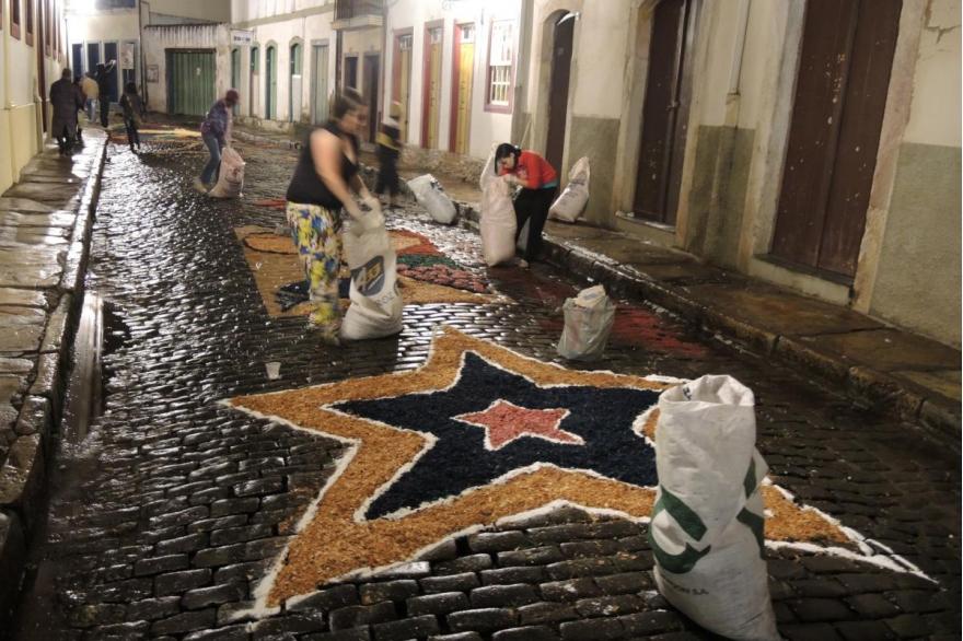 Groups begin filling in their designs with sawdust along the Easter procession route.