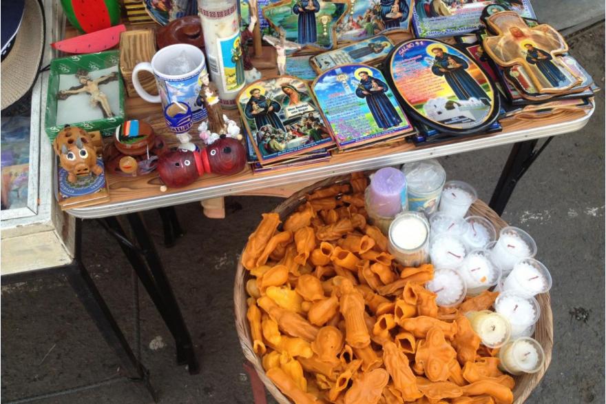 Religious goods for sale outside of church, San Antonio Sonsonate, El Salvador; the small orange wax figures are meant as ex voto offerings to San Antonio, the choice of body part depends on the kind of healing one needs.