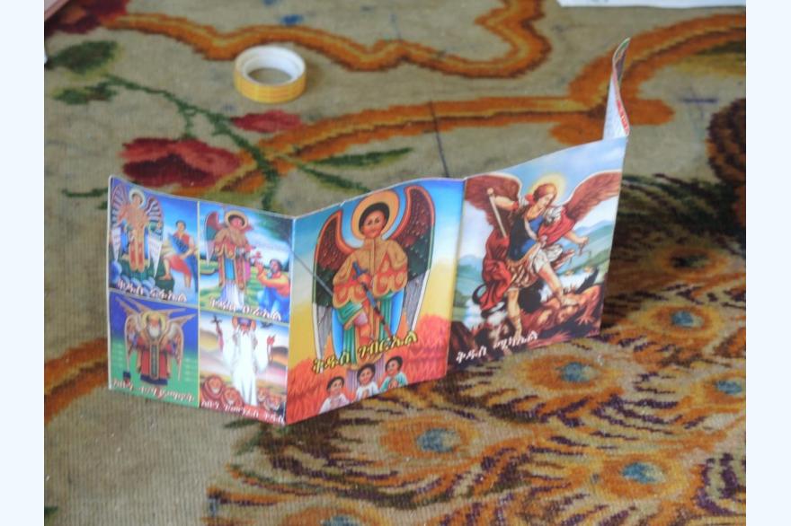 A prayer card features images of Orthodox saints.
