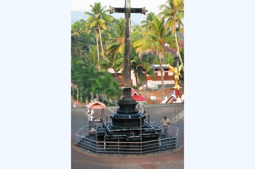 Worshippers come to add oil to the lamps as they pray, while circumnavigating the cross in front of St. Mary's Forane Syro-Malabar church, Kuravilangadu.