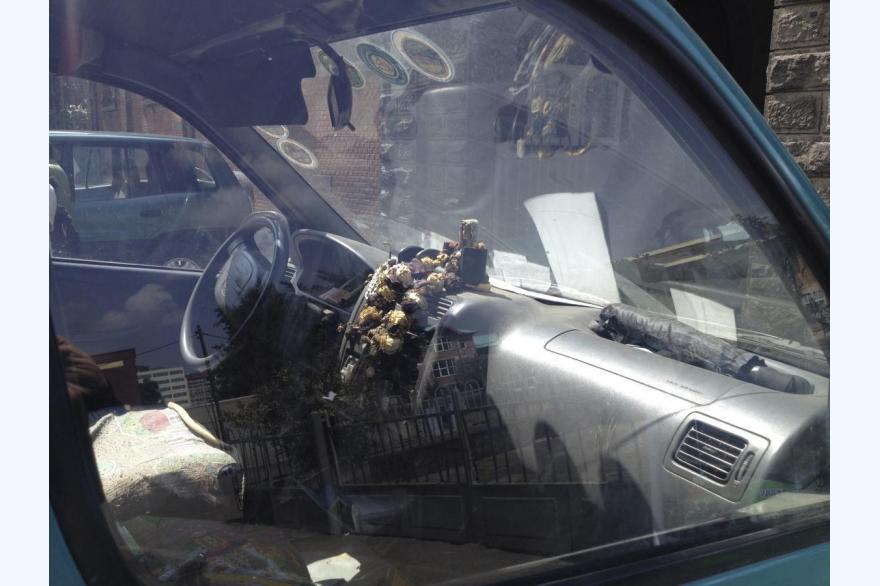 Religious articles in a family car in the lot of a Catholic church, Addis Ababa