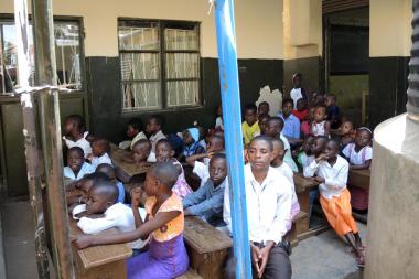 Young children from the neighborhood congregate to one side of the outdoor altar at Mass at St. Peter Claver school, Kampala, Uganda.