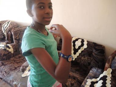 In Uganda, 11-year-old Holly shows off her favorite bracelet, with a variety of Marian images.
