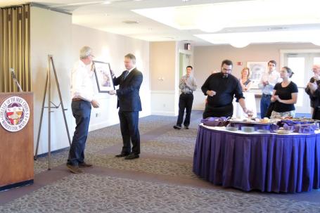 Thomas M. Landy, founder of Catholics & Cultures, presents editor Mathew N. Schmalz with a framed Journal cover at the launch reception.