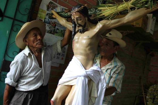 Members of the Hermandad in Izalco, El Salvador, prepare the image of Christ with a cross made with Corozo palms, on the morning of Holy Thursday. The image will be carried in the Procesion de los Cristos. Photo credit: Josue Parada/El Salvador