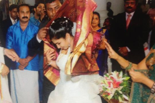 The saree, the blessed gift from the groom's family, is placed over the bride.